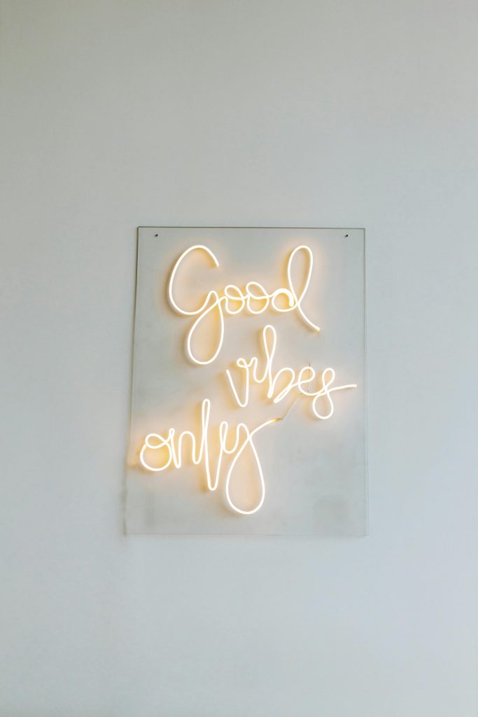 Illuminated neon sign featuring 'Good Vibes Only' against a minimalist backdrop.